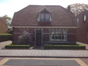 een rood bakstenen huis met een bruin dak bij B&B De Singel in Medemblik