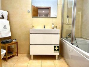 a bathroom with a sink and a bath tub at Mar e Sol by - T3 , wi-fi e estacionamento in Quarteira +25 photos