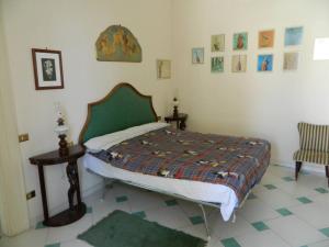 ein Schlafzimmer mit einem Bett, zwei Tischen und einem Stuhl in der Unterkunft Casa Vela in Ariano Irpino