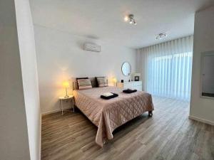 Un dormitorio con una cama grande y una ventana grande. en Anzol By FHR, en Quarteira
