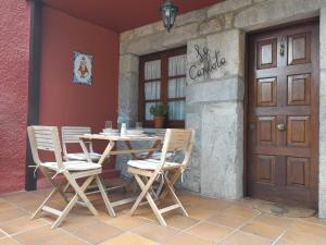 a table and chairs on a patio next to a door at La Carlota in Llames de Pría
