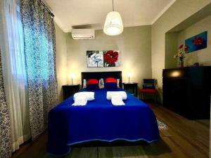 a bedroom with a blue bed with red pillows at Green House by FHR estacionamento e WI-FI in Quarteira