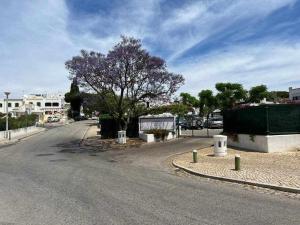 a street with a tree on the side of the road at Green House by FHR estacionamento e WI-FI in Quarteira