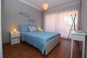ein Schlafzimmer mit einem blauen Bett und einem Fenster in der Unterkunft Millennium golf by FHR piscina & parking in Vilamoura + 16 Fotos