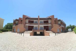 ein großes Backsteingebäude mit einem Innenhof davor in der Unterkunft Millennium golf by FHR piscina & parking in Vilamoura
