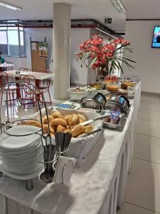 a buffet line with plates and pastries on at Hotel Regina Muriaé in Muriaé