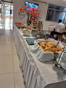 a long table with food on top of it at Hotel Regina Muriaé in Muriaé