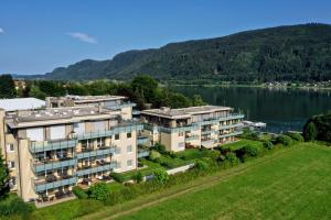 an aerial view of a building next to a lake at Apart Hotel Legendär in Steindorf am Ossiacher See