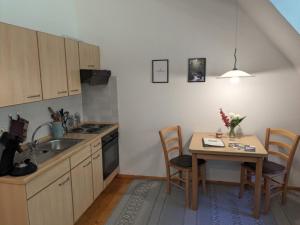 una cucina con tavolo, lavandino, tavolo e sedie di Haus 2 Hanselishof - 2 Wohnungen a Schenkenzell