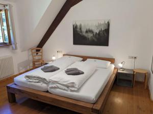 a bedroom with a large bed with white sheets at Haus 2 Hanselishof - 2 Wohnungen in Schenkenzell