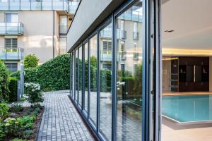 a glass facade of a building with a swimming pool at Apart Hotel Legendär in Steindorf am Ossiacher See