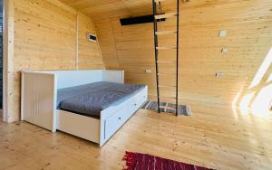 - une chambre avec un lit dans un mur en bois dans l'établissement Horezu Cozy Cabin, 