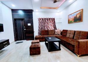 a living room with a brown couch and a table at Staeg Villa in the Center of the City 2BHK in Indore