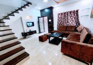 a living room with a couch and a staircase at Staeg Villa in the Center of the City 2BHK in Indore