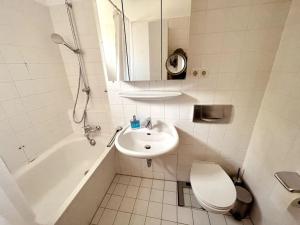 łazienka z umywalką, toaletą i wanną w obiekcie Gemütliche Wohnung mit Balkon in Schönefeld w Schonefeld