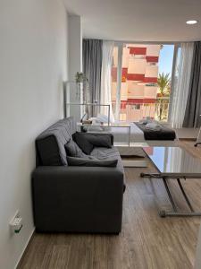 - un salon avec un canapé et une table en verre dans l'établissement Lux Studio Nerja, à Nerja