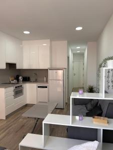cocina con armarios blancos y mesa blanca en Lux Studio Nerja, en Nerja