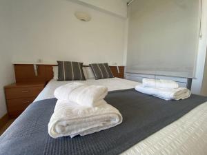 a bedroom with a bed with white towels on it at Gorliz Beach House in Górliz-Elexalde