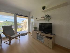 a living room with a flat screen tv and a chair at Gorliz Beach House in Górliz-Elexalde