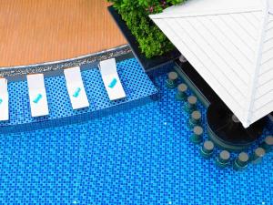een uitzicht over een zwembad met blauwe tegels bij Grand Mercure Phuket Patong in Patong Beach