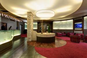 a lobby with a reception desk and red chairs at Best Western Gorizia Palace in Gorizia