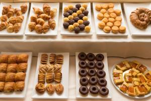 una exposición de diferentes tipos de donuts y bollería en Best Western Gorizia Palace en Gorizia