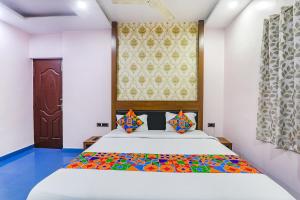 a bedroom with a large bed with a colorful blanket at FabHotel Astor in Gaya