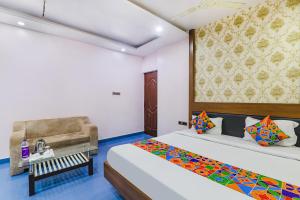 a hotel room with two beds and a chair at FabHotel Astor in Gaya