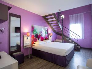 a purple room with a bed and a staircase at ibis Styles Bourges in Bourges