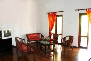 a living room with chairs and a table and a tv at Natures Bliss Garden Stay in Ja-Ela