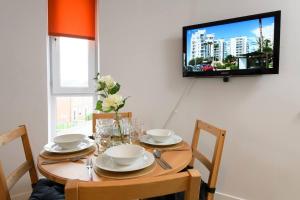 a dining room table with a television on a wall at 1 bed apartment close to Football Grounds in Liverpool