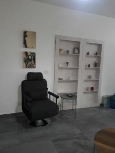 a living room with a chair and a table at Studio In Dbayeh In A Prime Location, Wifi, 38sqm in Dbayeh