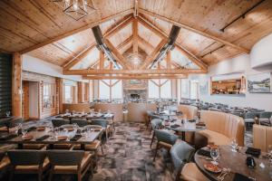 a restaurant with wooden ceilings and tables and chairs at Hilton Garden Inn Kalispell in Kalispell