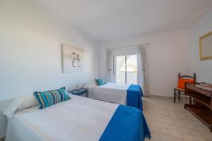 a hotel room with two beds and a piano at Villa Sharon in L'Escala