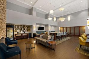 a lobby with furniture and a bar in the background at Hampton Inn & Suites Poughkeepsie in Spackenkill