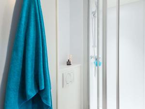 a bathroom with a blue towel and a shower at hotelF1 Nancy Nord Bouxieres in Bouxières-aux-Dames