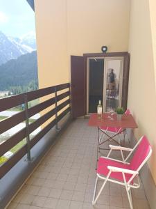 a table and two chairs on a balcony with a view at OHANA APARTMENT in Passo del Tonale