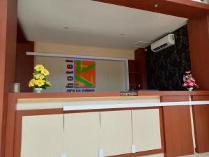 a kitchen with white cabinets and flowers on the counter at Karunia Hotel in Purwodadi