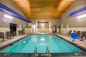 uma piscina num quarto de hotel com cadeiras e mesas em La Quinta by Wyndham Boone em Boone