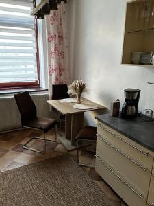 una cucina con tavolo e due sedie e una finestra di Schöne Wohnung in Bestlage inclusive Parkplatz a Lipsia