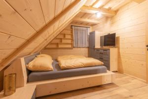sypialnia w drewnianym domku z łóżkiem i telewizorem w obiekcie Wellness Chalet Kohútka w mieście Lazy pod Makytou