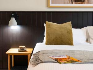 a bedroom with a bed and a table with a cup on it at Parklands Resort & Conference Centre in Mudgee