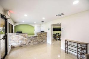 a living room with a stone wall and a bar at Quality Inn & Suites Downtown in Orlando