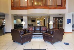 a lobby with a couch and two chairs at Wingate by Wyndham Coon Rapids in Coon Rapids