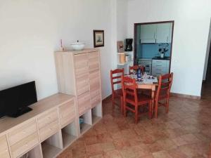 a dining room with a table and chairs and a television at Ocean Quarteira Vista Mar e central in Quarteira