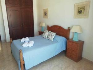 Un dormitorio con una cama azul con toallas. en Ocean Quarteira Vista Mar e central, en Quarteira