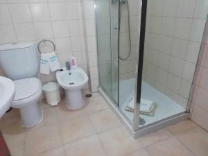 a bathroom with a shower and a toilet and a sink at Ocean Quarteira Vista Mar e central in Quarteira