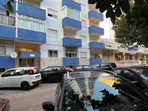 un estacionamiento con autos estacionados frente a un edificio en Ocean Quarteira Vista Mar e central, en Quarteira