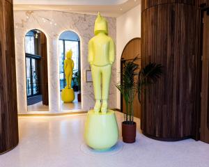 a large yellow statue in a room with mirrors at art'otel London Battersea Power Station, Powered by Radisson Hotels in London
