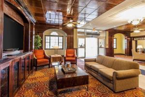a living room with a couch and a flat screen tv at Wingate by Wyndham Marietta Conference Center Ohio in Marietta